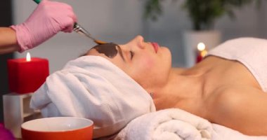 Yüz maskesi kaplıca tedavileri ve cilt bakımı. Güzellik salonundaki kadın yüz bakımı yaptırıyor..