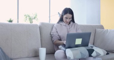 Evde dizüstü bilgisayarla çalışan heyecanlı bir kadın. Raporlarda uzak çalışma hatası ve serbest yazar kavramının son teslim tarihi