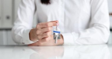 Emlakçı evin anahtarlığını evin anahtarlığında tutuyor. Emlak satışları ve kiralık daireler.