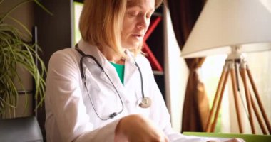 Çok çalışan yorgun bayan doktor ofiste oturuyor. Tıpta fazla mesai