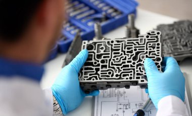 Hydroblock ayrıntılı tanılama ve tahminleri ayrıntılı test iletim closeup kurut otomatik şanzımanı otomatik Onarım Servisi tamirci mavi koruyucu eldiven elinde tutar.