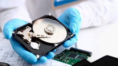 Mavi eldiven giymiş bir erkek tamirci bilgisayarınız veya dizüstü bilgisayarınız bir sabit diskten elinde tutuyor. Hata tanılama gerçekleştirir ve acil onarım kurtarma kayıp veri silme Hdd closeup sırasında gerçekleştirir