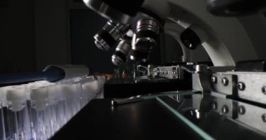 Modern elektronik mikroskoplar, laboratuvar camlarının yanında uzun sırada duruyor. Karanlık odada araştırma ve araştırma için profesyonel ekipmanlar