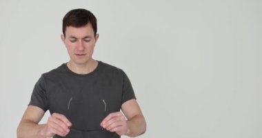 Siyah plastik çerçeveli gözlük takan adam 4K filmli ağır çekim. Vizyon testi ve gözlük seçimi konsepti