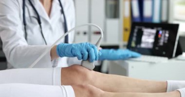 Ortopedi doktoru, hastanın dizini ultrasonda muayene ediyor. Diz ağrısı ve tedavi kavramı