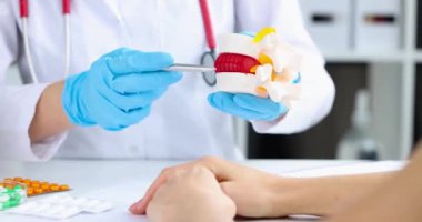 Doktor model üzerinde omurilik fıtığı olduğunu gösteriyor. Sırt ağrısı kavramı