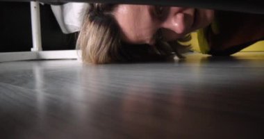 Temizlikçi kadın kanepenin altından siyah erkeklerin çorabını çıkarıyor. Konutlar ve konutlar için temizlik hizmetleri