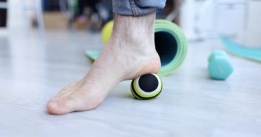 Man massaging his leg with ball on floor closeup 4k movie slow motion. Physiotherapy for foot problems concept