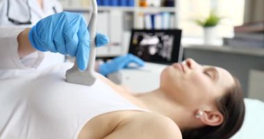 Doktor klinikteki hastanın göğsüne ultrason yapıyor. Ağır çekimde. Göğüs tümörü teşhisi