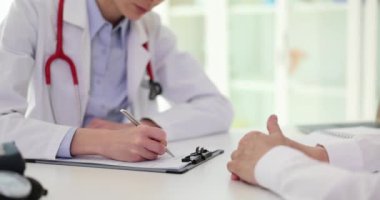 Steteskoplu odaklanmış doktor olgun hastaların tedavi planlarını panoya yazıyor. Klinikte ağır çekimde uzman bir kadınla randevusu var.