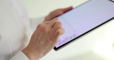 Kadın ofisteki tablet bilgisayar dokunmatik ekranına mesaj yazar. İş görevleri için dijital iletişim teknolojisi. İş yerinde aygıtı olan bir çalışan