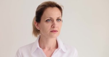 Şok olmuş bir kadın stüdyoda beyaz duvarın yanında duran inanılmaz şeyleri gözlemliyor. Duygusal bir kadın başını çevirip bakıyor.