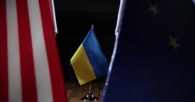 Ukrayna bayrağı, Amerika ve Avrupa Birliği bayraklarının yakınındaki ahşap masaya koyuldu. İzleyiciler arasında uluslararası konferans masası