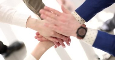 Ofisteki takım oluşturma faaliyetleri sırasında iş adamları el ele tutuşuyor. Ortak büyüme için iş birliği