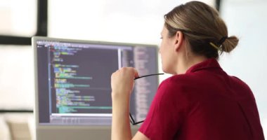 El kontrollerinde gözlüklü kadın programcı ofiste bilgisayarla çalışıyor. Yazılım geliştiricisi iş yerinde ağır çekimde oturur