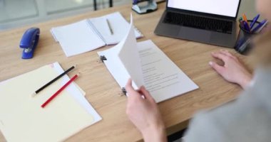 Kadın, elindeki kâğıt klasörünü dikkatlice senaryoyla açıyor. Aktris kendi repliklerini arıyor. Senaryo ahşap ofis masasında kağıtlar ve kırtasiye malzemeleriyle ağır çekimde duruyor.