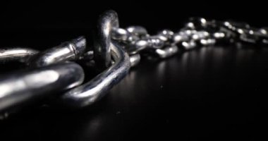 Çelik ve gümüşten yapılmış ağır zincirler sırada bekliyor. Farklı amaçlar için galvanize büyük sert zincirler Karanlık stüdyoda siyah yüzey koymak