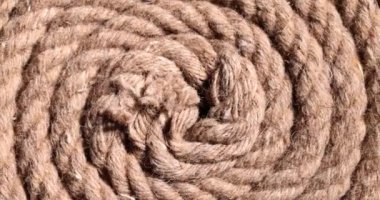 Pamuktan yapılmış kalın, sarmal bir ip yerde yatıyor. Eskimiş kenevirden yapılmış eski bir yelkenli ipi. İp parlak ışıkta ağırlık kaldırmak için tasarlandı