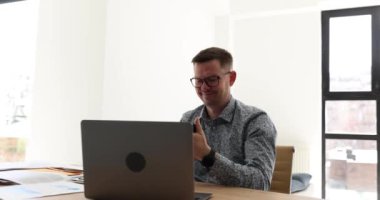 Erkek yönetici ofiste bilgisayar başında çalışıyor ve telefona cevap veriyor. Konuşkan adam cep telefonuyla neşeli bir şekilde konuşuyor. Başarılı iş adamı çalışma gününü tartışıyor