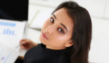 Masasında belgeleri olan esmer bir kadının portresi. İş istatistikleri kavramı