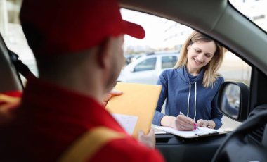 Kadın evrakları imzalıyor ve sarı bir zarf alıyor. Ekspres dağıtım kavramı