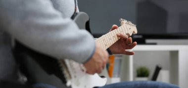 Evde erkek el oynayın ve elektro gitar müzik yapan melodi müzik notasyon büyük kavramı closeup zevk dinleme fark eder