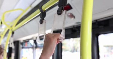 Otobüste el ele tutuşan bir kadın. Yakın çekim 4K film ağır çekim. Toplu taşıma güvenlik kuralları kavramına göre seyahat