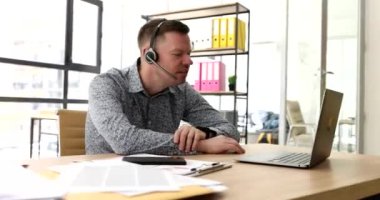 Kulaklıklı, mikrofonlu, laptop ekranı aracılığıyla iletişim kuran ve orta parmak 4K filmi gösteren kaba bir ajan. İş ahlakı kavramının ihlali