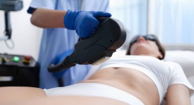 Kozmetik uzmanı lazer yakın çekim kullanarak istenmeyen kılları vücudundan alıyor. Estetik ilaç lazer tüy temizleme konsepti