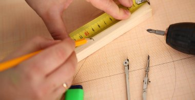 Ustabaşı ahşap parçaya çizgi çeksin, mezura ve kalem kullansın. İnşaat alanında yetenekli bir işçi. Yenileme, inşa, mimar konsepti