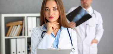 Genç bir tıp uzmanı olan önlüklü uzman doktor portresi klinikte çalışmaya başlıyor. Sağlık, ilaç, acil durum, hayat kurtarma, yardım, hastane konsepti