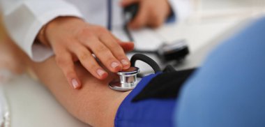 Hemşirelerin kan basıncını klinikteki tonometre cihazıyla ölçmeleri gerekiyor. Randevusu olan hasta, insanlara yardım ediyor. Tıp, bilim, tanı, kontrol kavramı