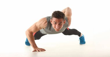 Portrait of strong man perform biceps and triceps workout at home without equipment. Sport trainer train with smile, sweaty. Physical activity concept
