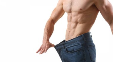 Kaslı, kaslı, karın kaslı, zayıf vücutlu, mükemmel vücutlu, büyük pantolonlu güçlü bir adam. Spor hocası, profesyonel model. Spor, modellik konsepti