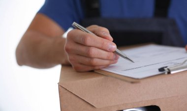 Adamın biri teslimat makbuzuna imza atmış, teslimat şirketinden paket almış. Teslimat servisi, nakliye, adres teslim konsepti