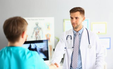 Uzman bir meslektaşın portresi, dostane bir el sıkışma hareketi, zeki bir doktor tıbbi üniforma giyer. Tıp konferansı, stajyer, sağlık konsepti