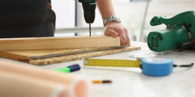 Tamir için işçi aletlerine yakın çekim, ahşap tahtada insan delme deliği. Masadaki dağınıklık. İnşaat, inşaat, yenileme, marangoz konsepti