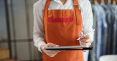 Üniformalı kadın ellerinde stil olan tablet. Düzen konsepti alınıyor ve yayınlanıyor