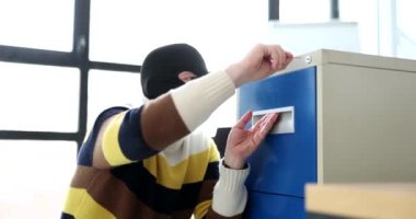Yüzünde siyah maske olan zeki bir hırsız şarjörle kilidi açar. İsimsiz bir adam çekmecedeki değerli belgelerin olduğu dosyayı açıyor.