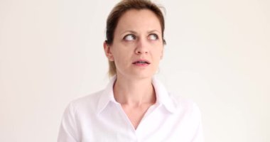 Şüpheli kadın başını yana çevirip bej arka planda geniş bir göz açıyor. Gergin kadın yeni alanı yavaş çekimde inceliyor.