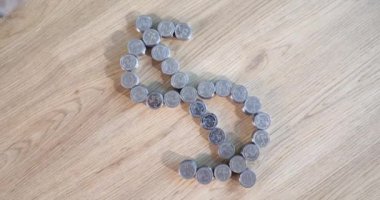 Tahta masadaki gümüş paralardan yapılmış dolar işareti. Para biriktirme ve birikim. Popüler para sembolü. Finansal tasarruf kavramı