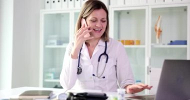 Pozitif kadın doktor, bilgisayardaki telefon tedavi planında hastayla konuşuyor. Uzman uzmanlar tavsiyelerini uzaktan verir.