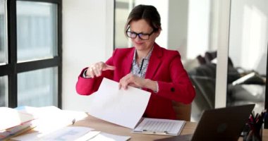 Sinirli kadın kâğıt çarşafa buruşup parçalara ayrılır. Gözlüklü yorgun bayan yönetici yırtık kağıt parçalarını yavaş çekimde fırlatıyor.