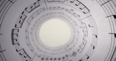 Müzikal notalar için hazırlanmış çubuklarla birlikte boru yazısıyla bükülmüş. Müzik kağıdı rulo beyaz masa üzerinde duran çizgiler ve notalar delik açar