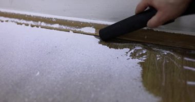 Foreman, duvarları işledikten sonra tahta zemine beyaz macun bırakıyor. Adam oturma odasının yerlerini temizliyor. Yenileme işlemi yavaş çekim