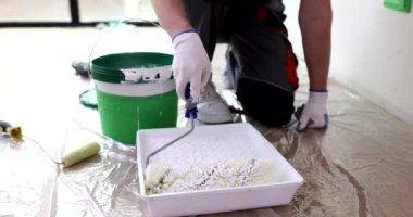 Koruyucu eldivenli bir adam yere serilmiş filmdeki duvarları incelemek için alçıya sarar. Foreman yavaş çekimde tadilat yapmaya hazır.