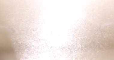 Odadaki lambadan gelen parlak ışıkta dönen beyaz zımpara tozu. Bej duvarlara dayanan küçük parçacıklar. Ağır çekimde yenileme işlemi