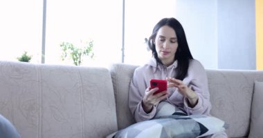 Akıllı telefon kullanan rahat genç bir kadın sosyal medyaya girip haberleri kontrol ediyor. Sosyal medya kullanımı ve telefon bağımlılığı kavramı