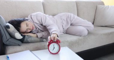 Yorgun uyuyan kadın, çalar saati yastığın altına saklar. Aşırı çalışma ya da kronik yorgunluk sendromu konsepti