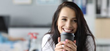 Gülümseyen kadın elinde siyah kağıt moog ile kahve içen portriat tutuyor. Sabah enerjisi kavramı